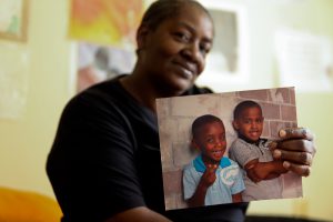 Thomascene Washington holds a photo of her grandsons who participate in the Washington Addition early childhood literacy program.