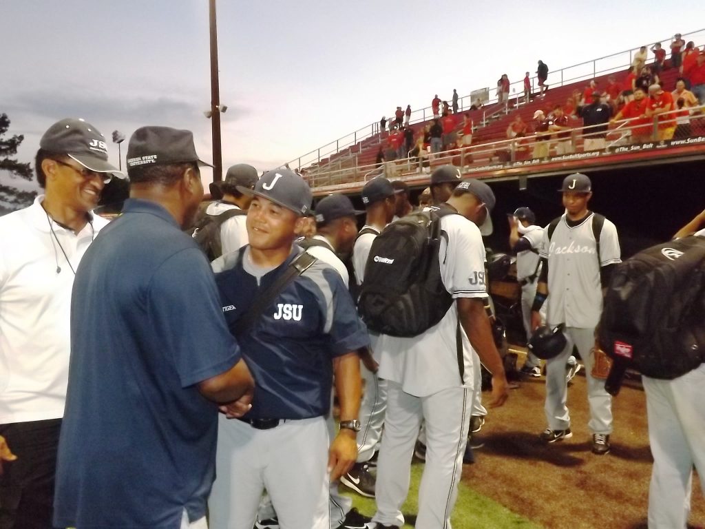 Albert Leason, left, and Wayne Goodwin, center, congratulates JSU coach Omar Johnson after his baseball Tigers upset top-seeded University of Louisiana-Layfayette during NCAA action on Friday.
