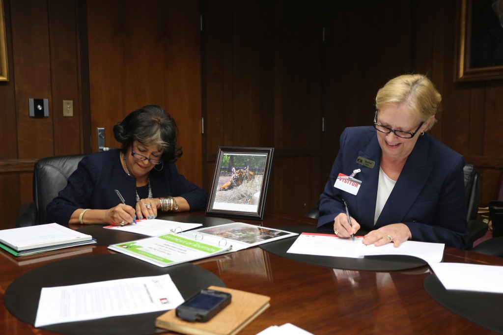 JSU President Dr. Carolyn Meyers (left) and Jackson Zoo Executive Director Beth Poff sign an agreement between the university and the zoo for JSU sponsorship of a Sumatran tiger cub named EKO at Meyers' office on Tuesday, Nov. 12, 2014. (Photo by Charles A. Smith, JSU)