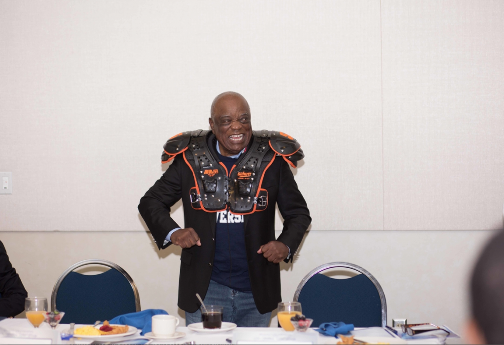 Dr. William “Bill” Cooley dons shoulder pads presented to him by President Carolyn W. Meyers as a gesture of appreciation for allowing many to lean on him for support. (Photo by Justin Hardiman/JSU)