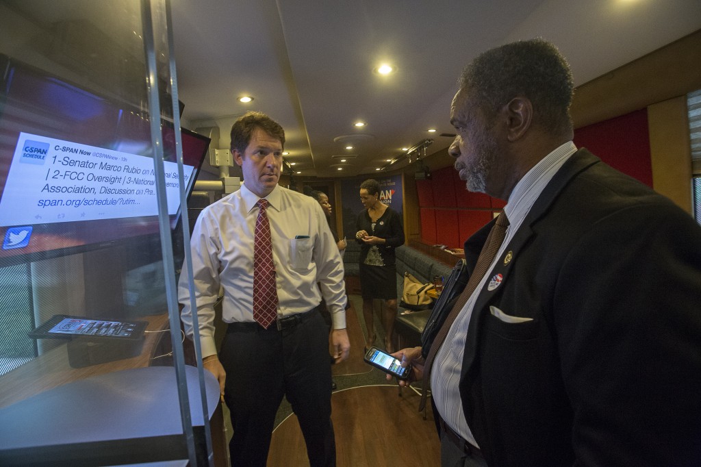 Heath Neiderer, marketing manager for C-SPAN’s Washington, D.C., office explains the multimedia interactive technology on the bus to Dr. Otha Burton, executive director of JSU’s Institute of Government. (Photo by Charles A. Smith/JSU)