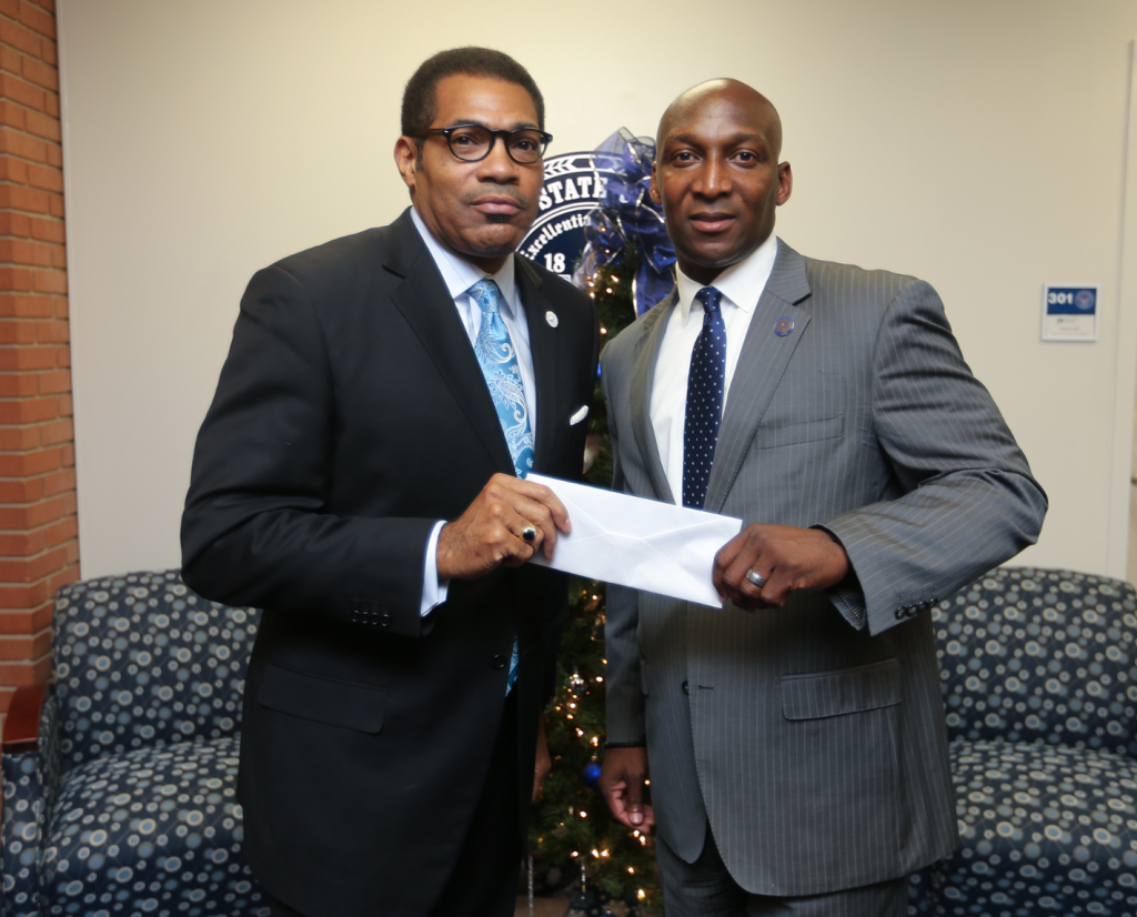 Dr. Alfred L. Martin Jr., left, the new chair of the JSU Development Foundation Board of Directors, presents a check to Anthony L. Holloman, vice president for Institutional Advancement, to show his support for the School of Journalism and Media Studies. (Photo by Charles A. Smith/JSU)