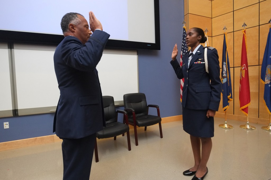 Col. Dewey Holmes (Ret.) of Arizona administers the oath elevating Air Force ROTC cadet Brittany Lynn to second lieutenant during her commissioning and pinning ceremony. Lynn will now train to become a combat systems officer. (Photo by Charles A. Smith/JSU)