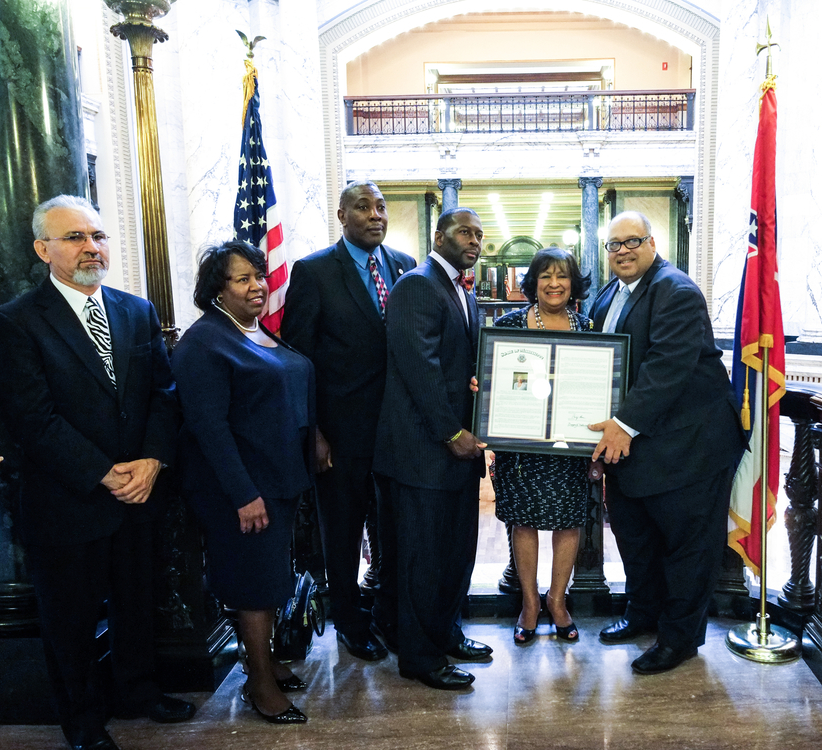 Dr. Carolyn W. Meyers proudly displays the House resolution presented in her honor. She’s joined by Dr. Mohammad Shahbazi, left, interim dean of the School of Public Health (Initiative); Dr. Loretta Moore, vice president for Research and Federal Relations; Public Safety chief Thomas Albright; state Rep. Chris Bell, District 65; and state Rep. Earle Banks, District 67. (Photo by Charles A. Smith/JSU)