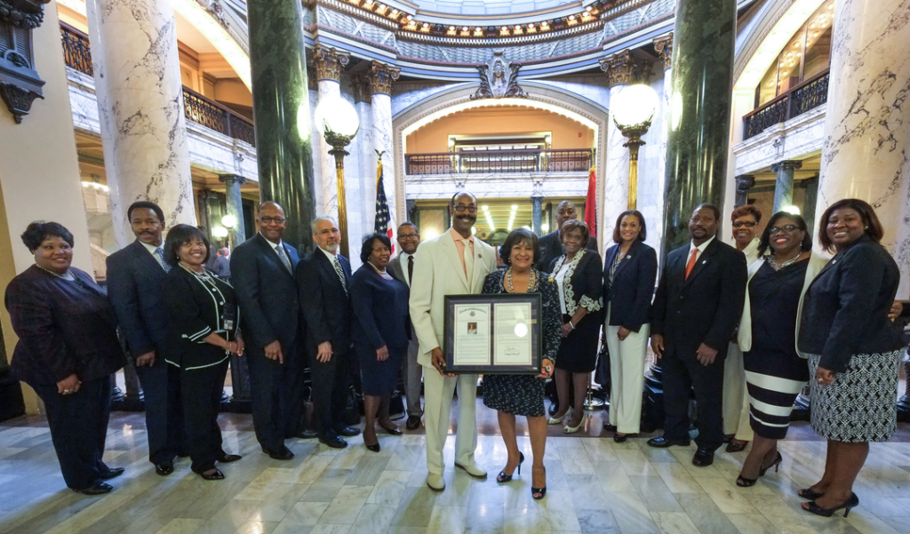 Mississippi state Rep. Gregory Holloway Sr., District 76, helps showcase a resolution honoring Jackson State University President Carolyn W. Meyers, with her Cabinet and staff. (Photo by Charles A. Smith/JSU)