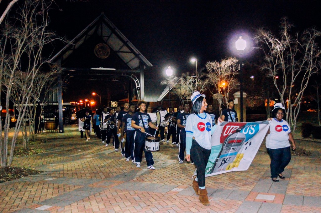 The drumline of the Sonic Boom of the South leads a debt funeral parade with volunteers following the procession.