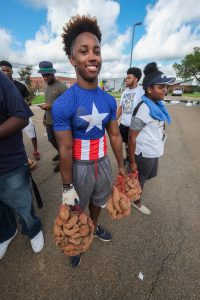 Freshman Jordan Jefferson displays her superhero strength as he carries pounds of sweet potatoes. (Photo by Charles A. Smith/JSU)