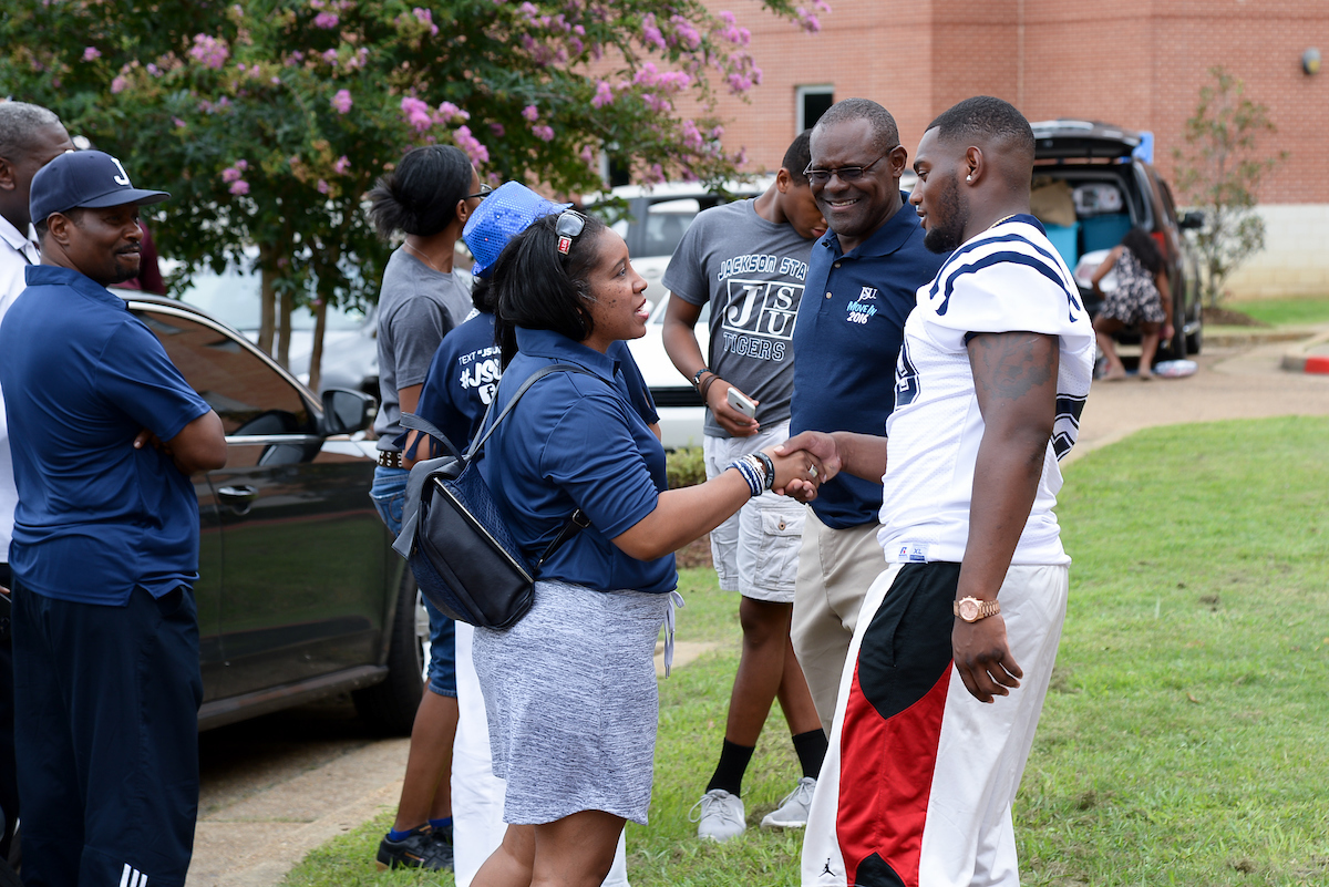Yolanda Owen, president of the Jackson State University National Alumni Association, thanks representatives for the JSU Tigers football squad, including Coach Tony Hughes, for helping out incoming freshmen. (Photo by Darek Ashley)
