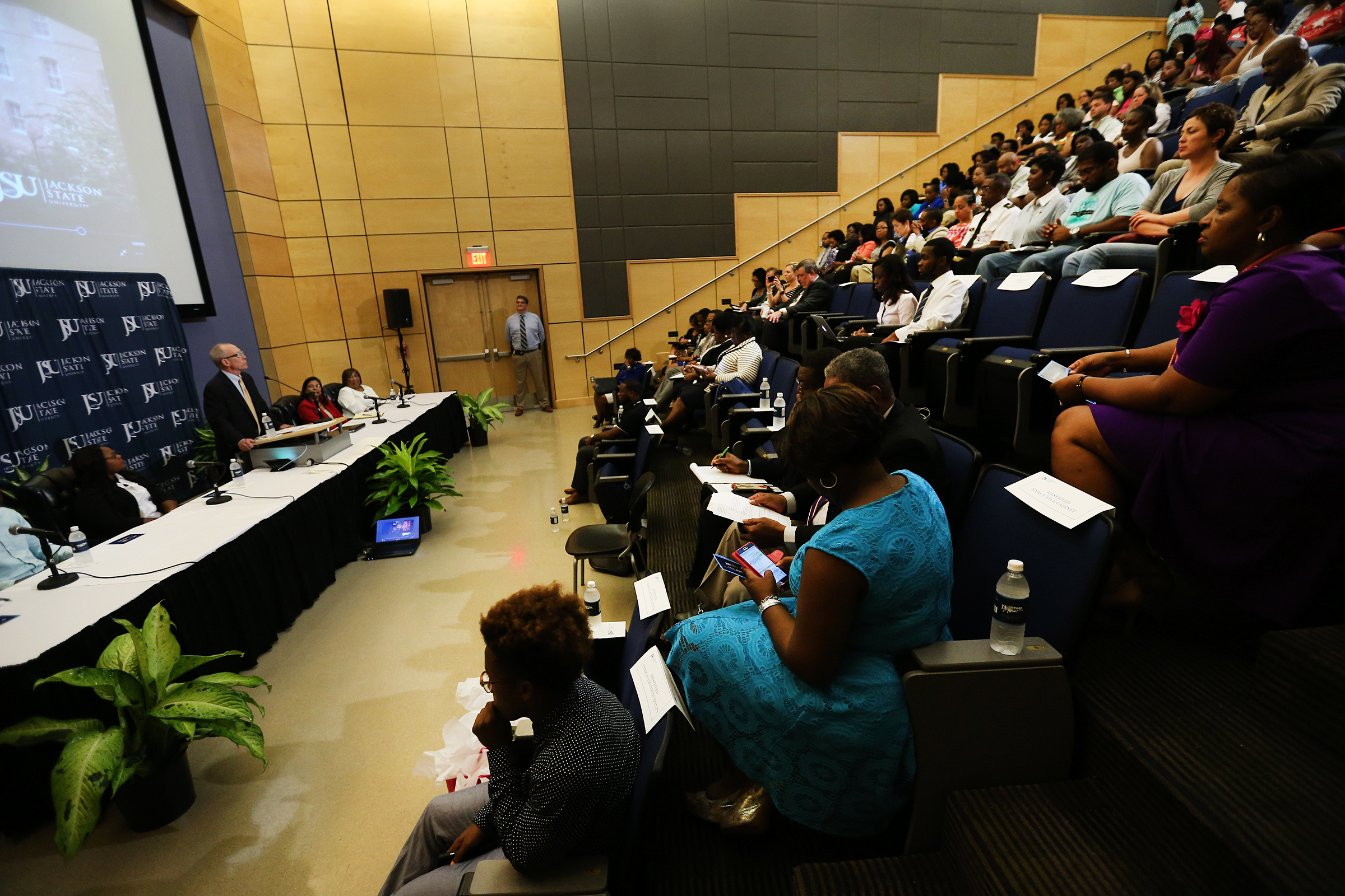 Dozens of students and educators listen to U.S. education officials discuss dual enrollment and First in the World initiatives Thursday in the auditorium of the College of Science, Engineering and Technology. (Photo by Charles A. Smith/JSU)