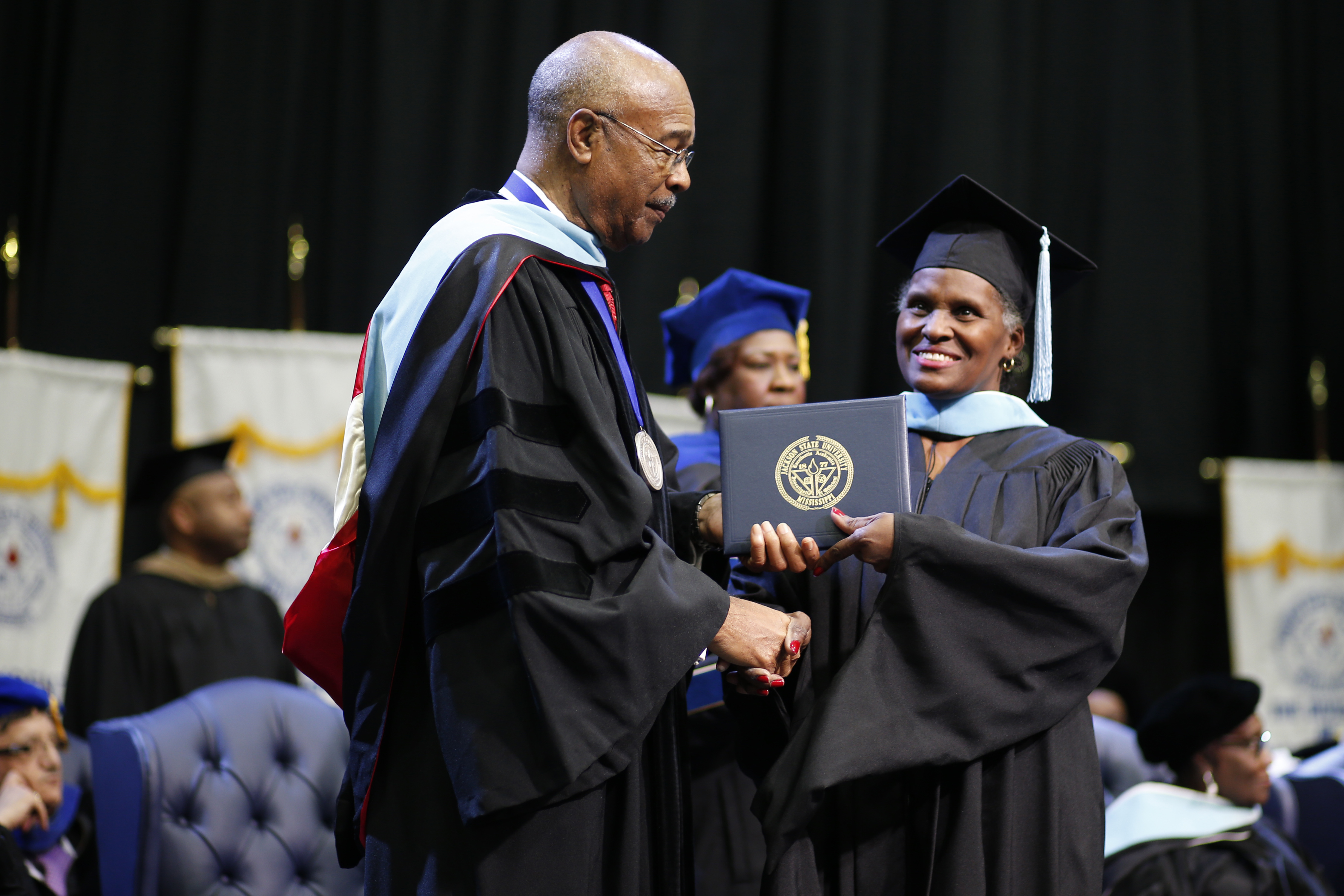 Sharon Rainey, 56, a Jackson State University alum, accepts her specialist degree from interim JSU president Rod Paige. Rainey uses her past experiences to inspire new generations of students. After earning her GED, working as a laborer and overcoming health challenges, she continued her education to become an elementary teacher for Jackson Public Schools. (Photo By Charles A. Smith/JSU)