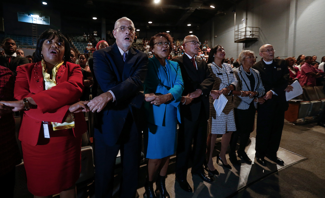 The audience, with crossed arms, joins hands while singing “We Shall Overcome.” Brown Henderson, whose family was central to the 1954 U.S. Supreme Court decision, urged JSU students and faculty to keep “marching; writing op-eds to the newspapers about what you think and what’s going on; using social media for good; forming coalitions and being politically active at every level.” (Photo by William Kelly/JSU)