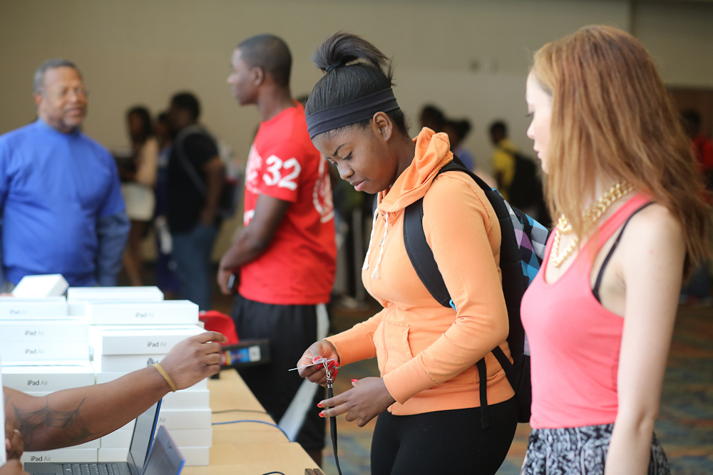 E-center staffers present gleeful first-time freshmen with iPads during the fifth consecutive distribution courtesy of the e-Center Foundation. (Photo by Charles A. Smith/JSU)