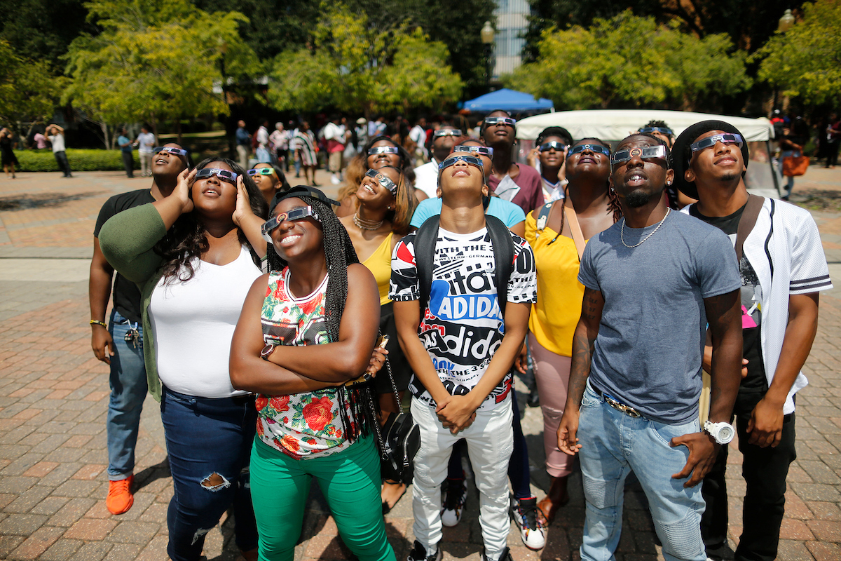 Awestruck students standing on the Gibbs-Green Plaza are all aglow as they gaze into the sky. (Photo by Charles A. Smith/JSU)