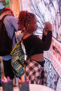 A student signs her name on the Truth mural making a pledge to abstain from smoking. (Photo by Charles A. Smith/JSU)