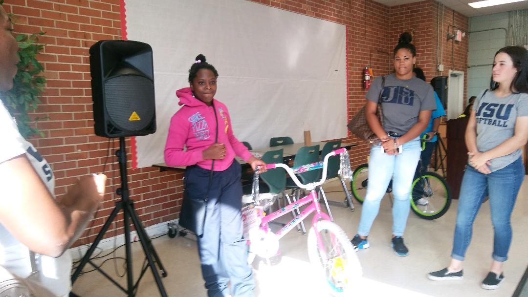 A student is honored for not missing a day of school. Each month, two students will be awarded a bicycle.