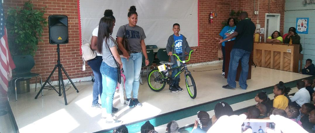 Another honored student proudly shows off his new bicycle.