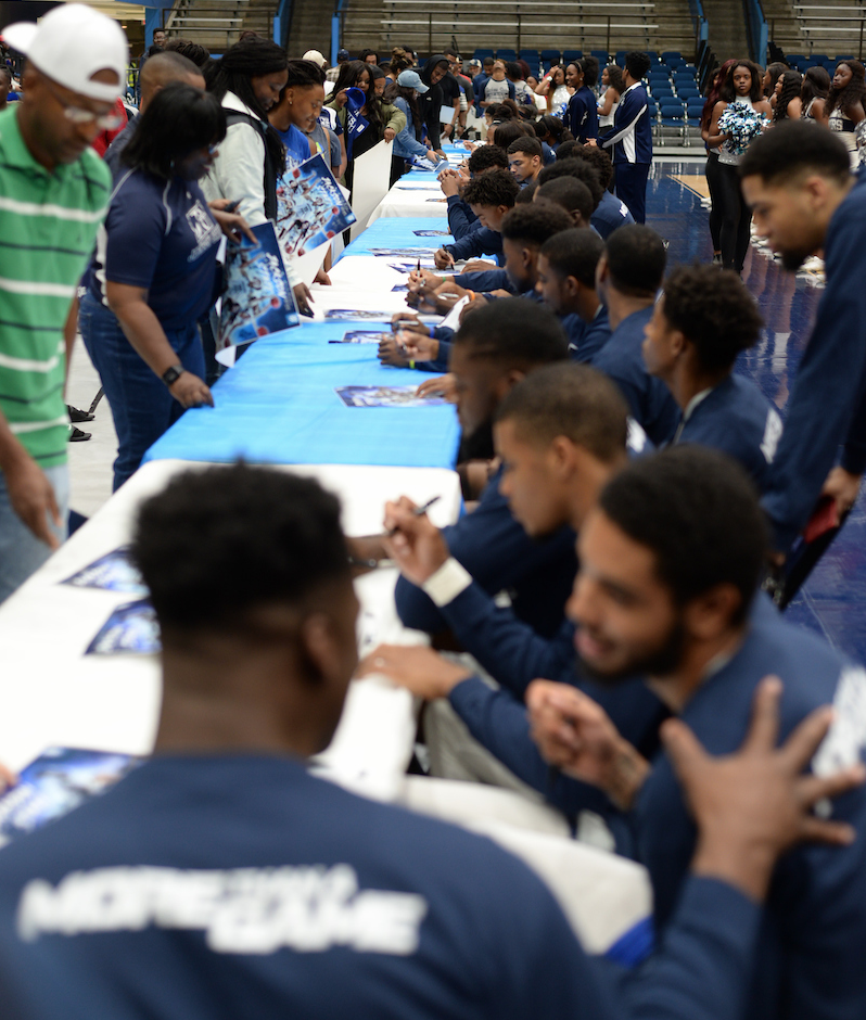 Members of the men’s team also sign autographs on commemorative posters. (Photo by Darek Ashley/JSU)