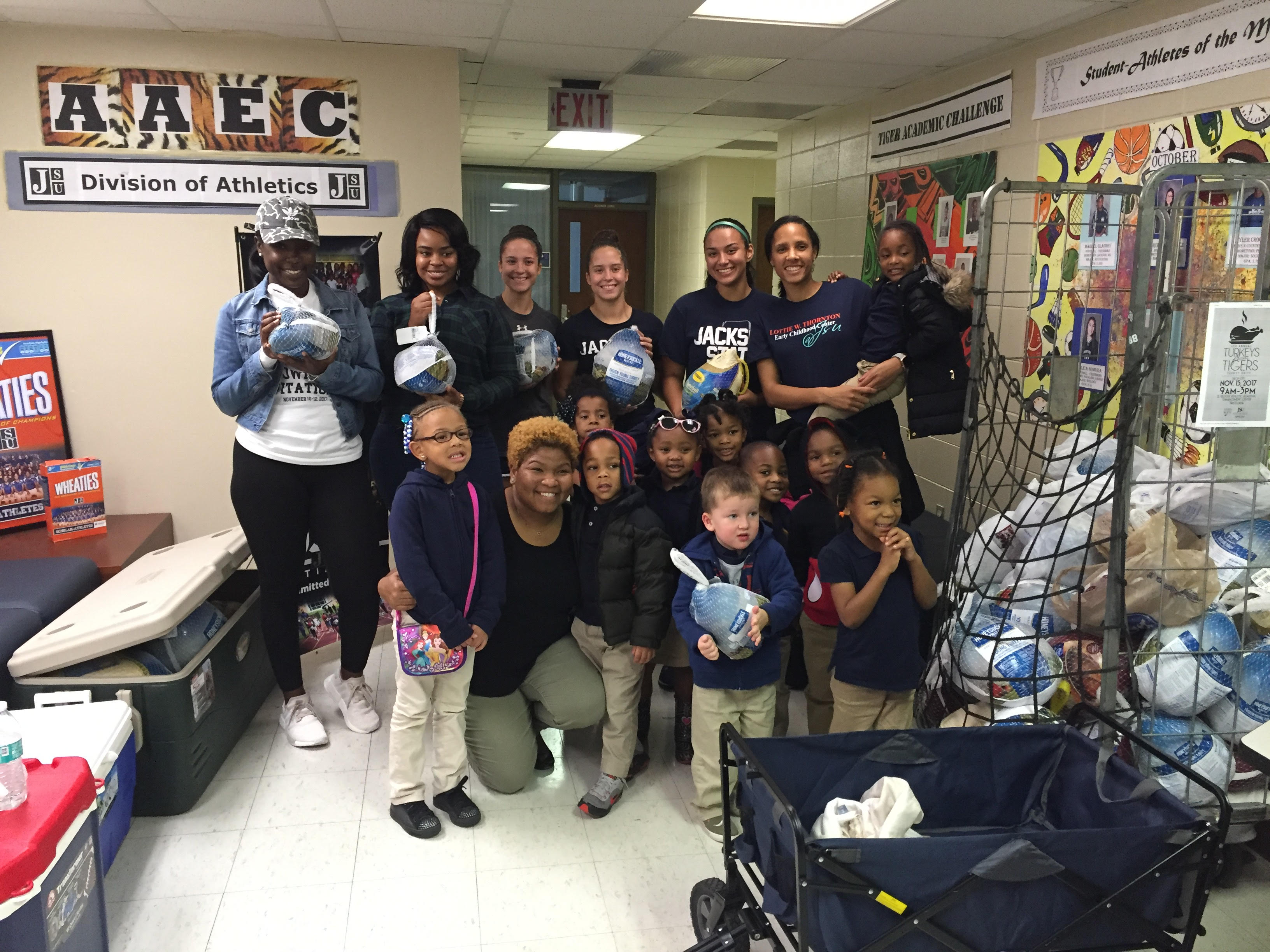 Student-athletes join children from Kids College admiring the collection of turkeys.
