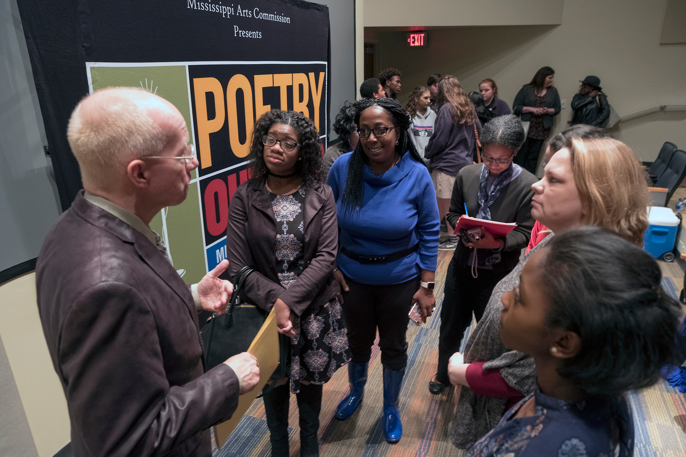 Ken Bolinsky, state coordinator for Poetry Out Loud, offers constructive criticism to the three finalists as they listen attentively surrounded by their school instructors. "We have to do our best to encourage and prepare the kid to be the winner," he said. (Photo by Charles A. Smith/JSU)