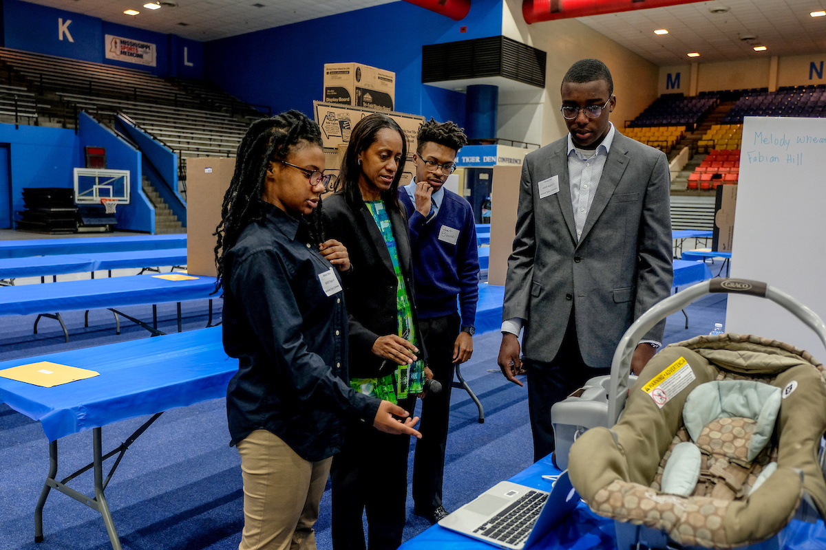 Dr. Jacqueline Stevens, a JSU biology professor in the College of Science, Engineering and Technology, discusses a project with students from Jim Hill High School. During the 45th Region II Science Fair, the students presented the Baby Beeper. One of its main features is to help ensure that a child is securely buckled in a car seat. (Photo by Charles A. Smith/JSU)