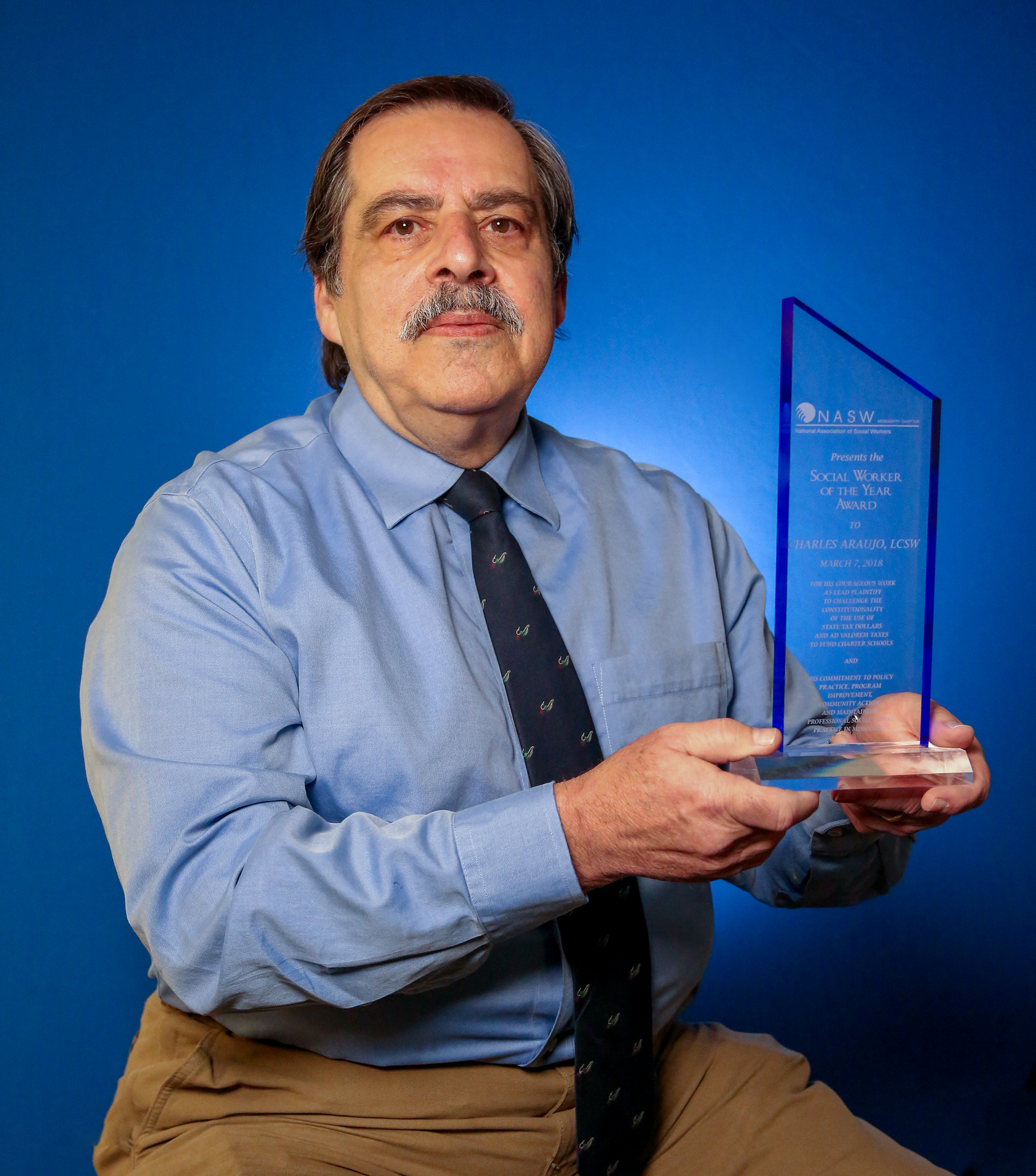 CPS adjunct professor Charles Araujo proudly displays his NASW Mississippi chapter Social Work of the Year Award. The award states "For his courageous work as lead plaintiff to challenge the constitutionality of the use of state tax dollars and ad valorem taxes to fund charter schools and his commitment to policy practice, program improvement, community action, and maintaining professional social work practice in Mississippi".