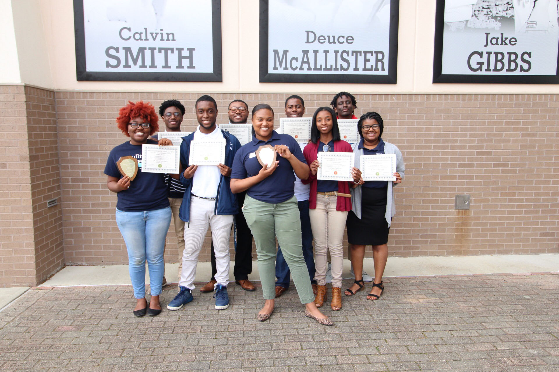 Staff members of JSU's student-led newspaper The Blue & White Flash show off the many awards they received from the Mississippi Press Association. (Photo special to JSU)