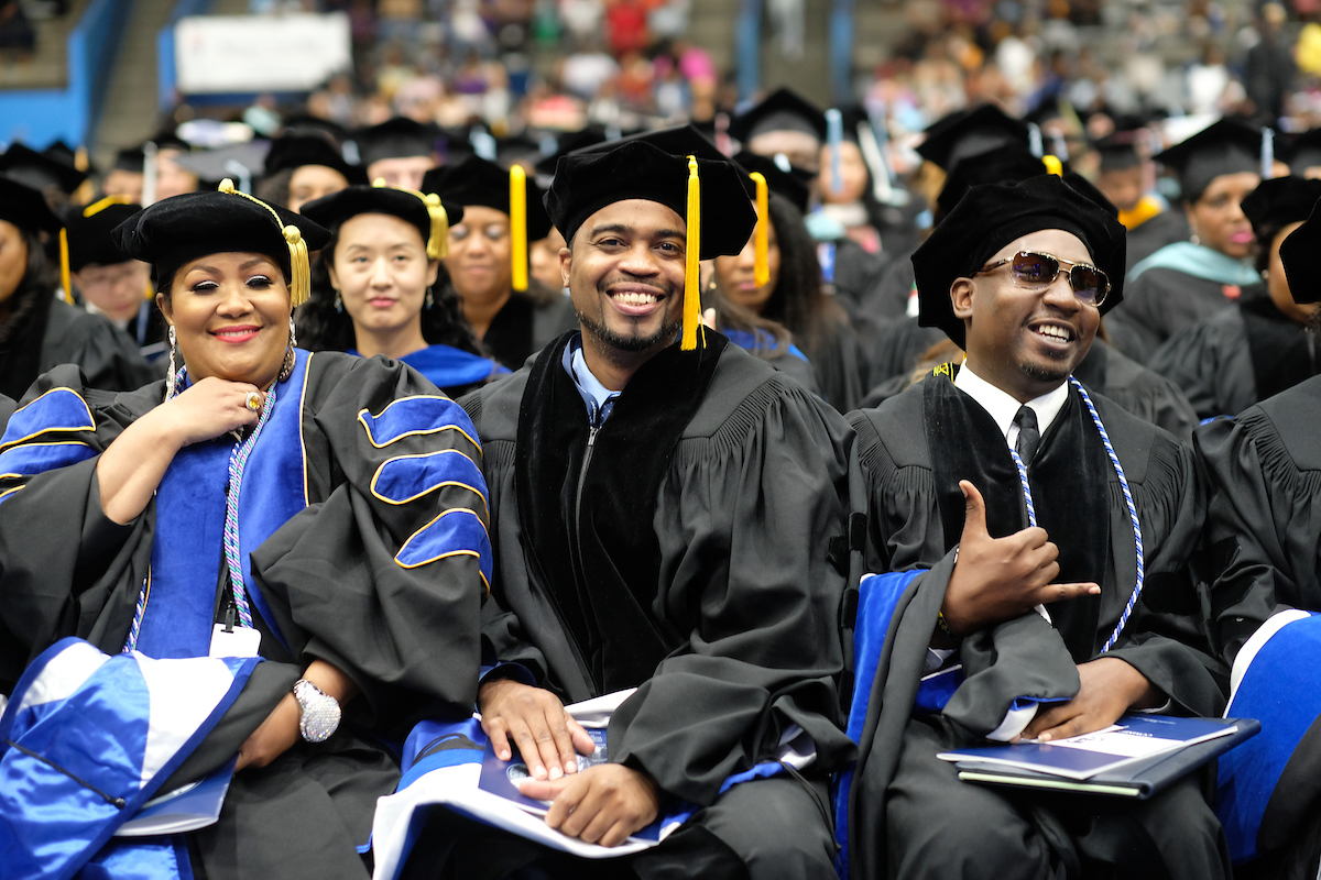 Verjaun P. Gordon, middle, celebrates with his peers as he prepares to receive his doctorate in education administration. (Photo by Charles A. Smith)