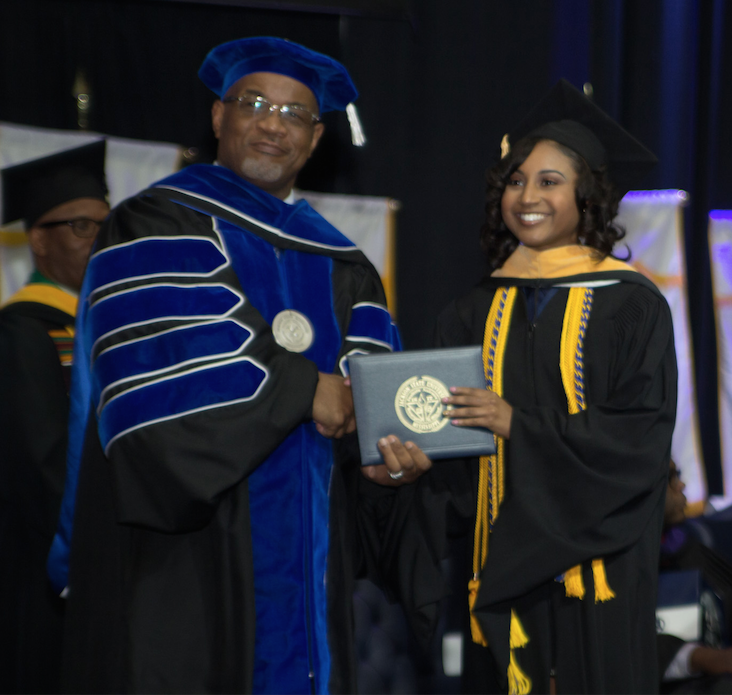Tershuna Bass accepts her Master's degree from JSU President Dr. William B. Bynum, Jr. just one year after receiving her Bachelor's degree. (Photo by Charles Smith)