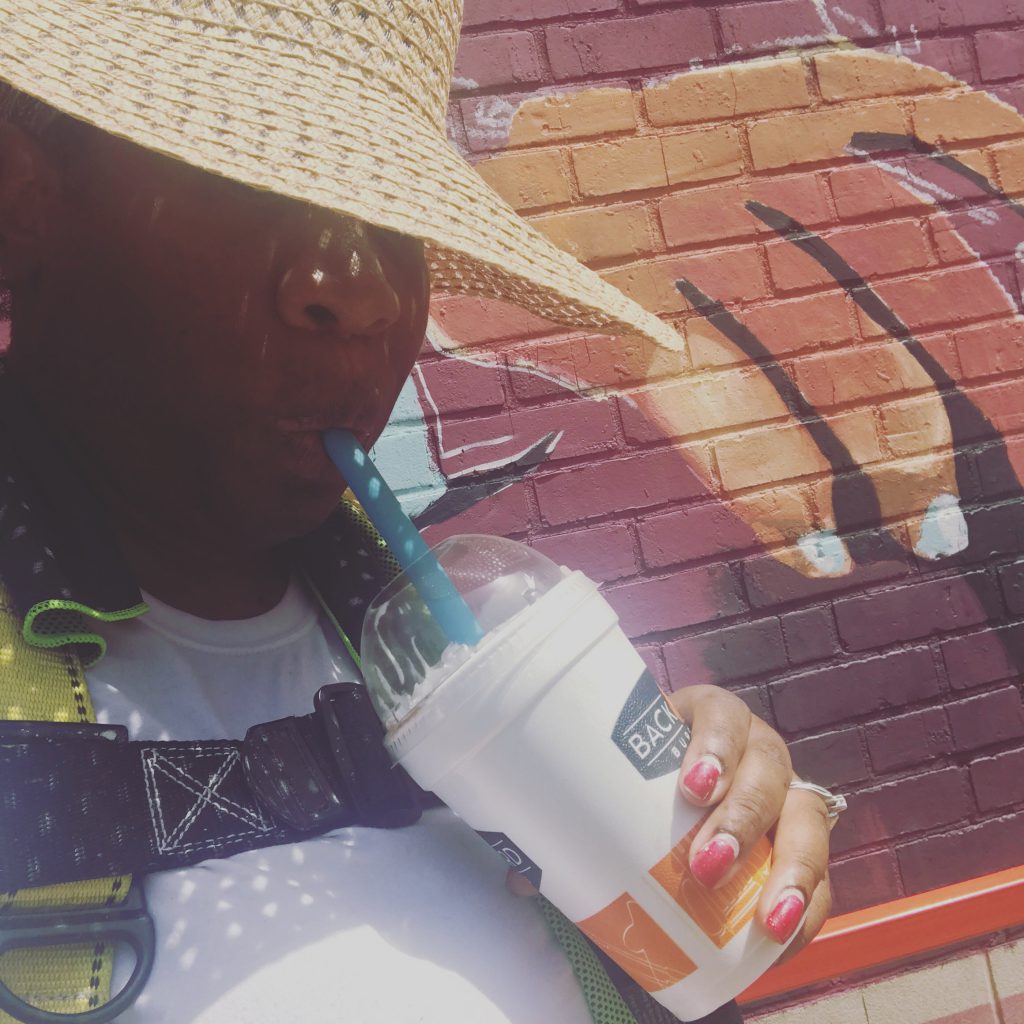 Graphic designer Talameika Brice pauses for refreshment while working to finish a larger-than-life depiction of former President Barack H. Obama. The Greater Jackson Arts Council selected Talameika's sketch to adorn the south side wall of the elementary school renamed in the former president's honor. (Photo special to JSU.)