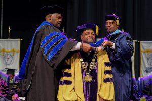 Dr. George French, president of Miles College in Birmingham, AL is hooded during the fall 2018 commencement exercise. (Charles A. Smith/University Communications)
