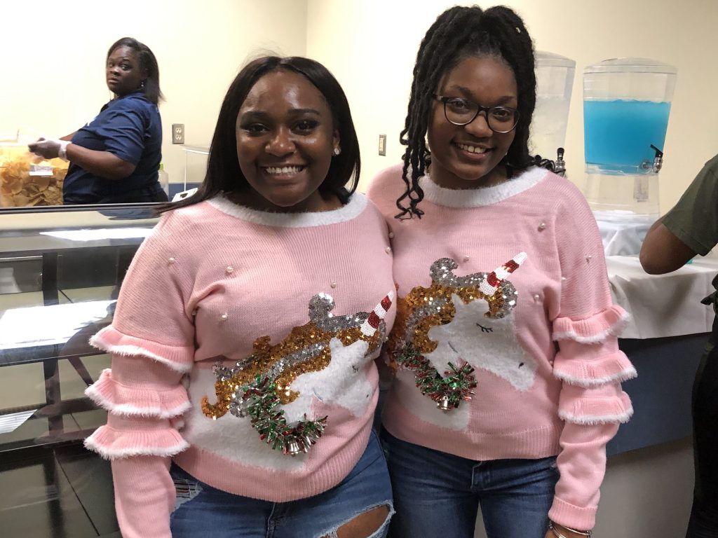 Keanne Williams, left, and Briana Simmons wear twin “ugly” sweaters at the Midnight Breakfast/holiday soiree. (Photo by L.A. Warren)