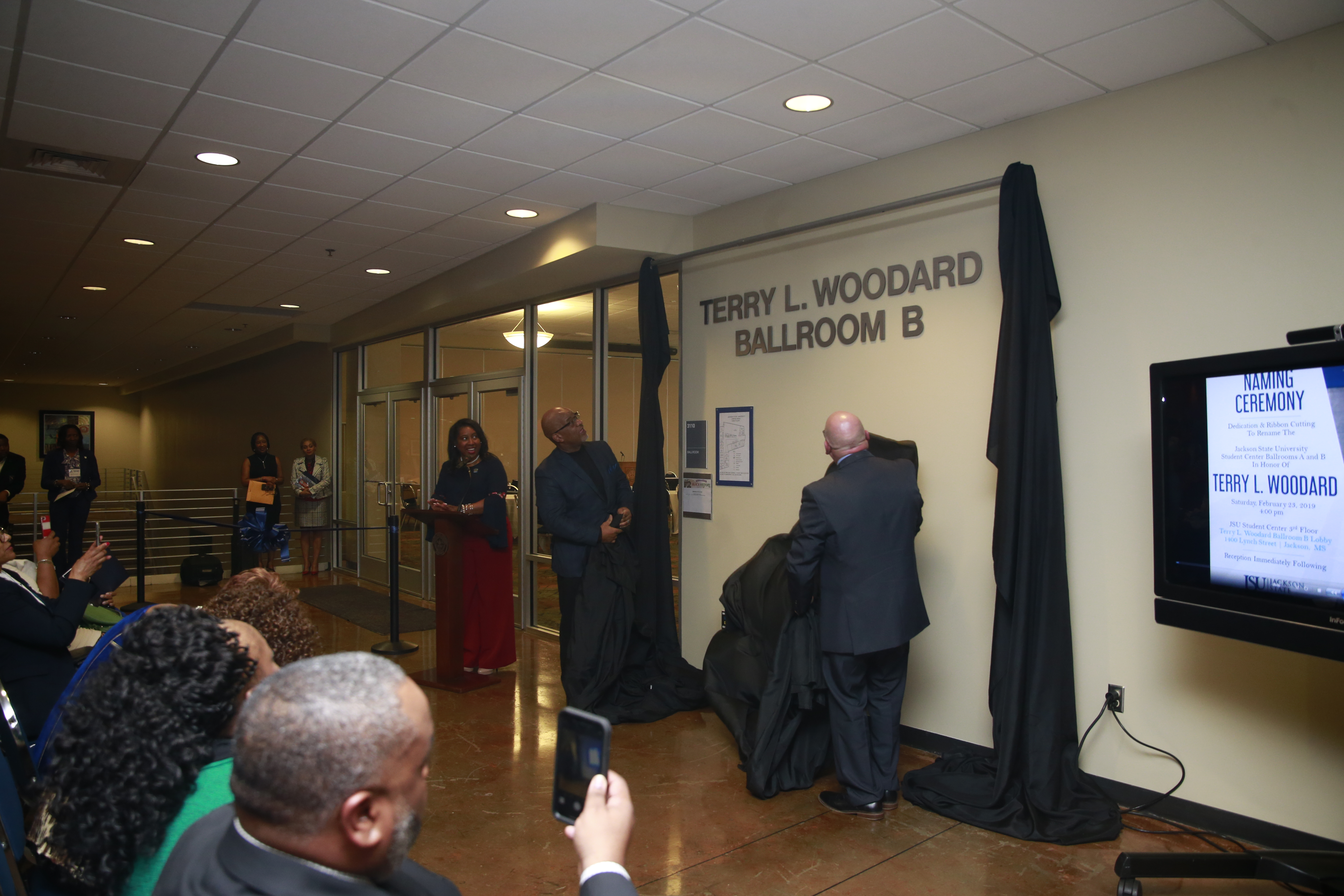 Family and friends of the gathered to witness the unveiling dedication of student ballrooms A & B to the late Terry L. Woodard.