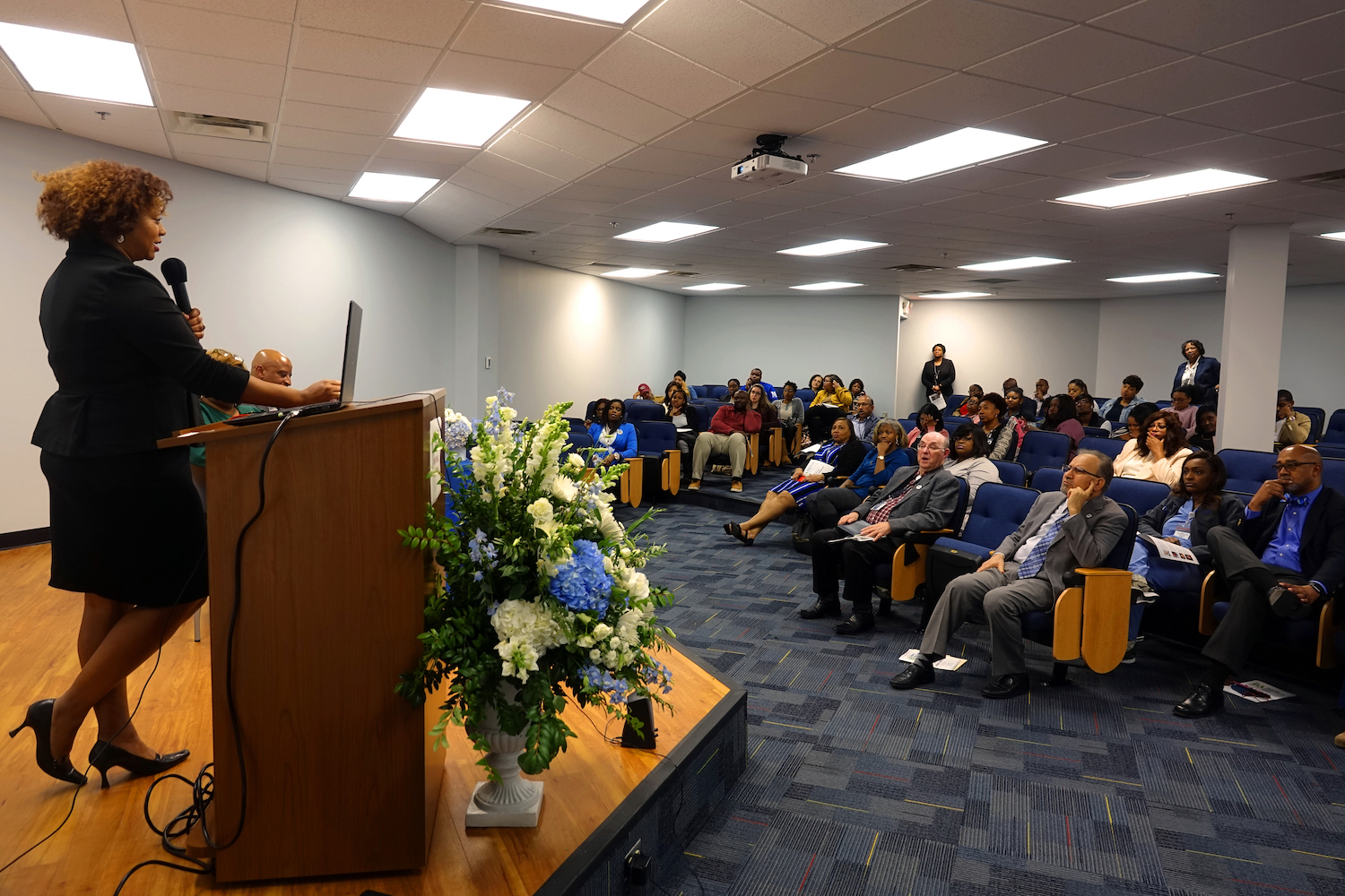 Erin Shirley Orey, a JSU master’s of public health student, serves on the board of the Drs. Aaron and Ollye Shirley Foundation, which is named in honor of her deceased parents. She tells the audience that the foundation aims to provide educational opportunities and mental and physical health care services.