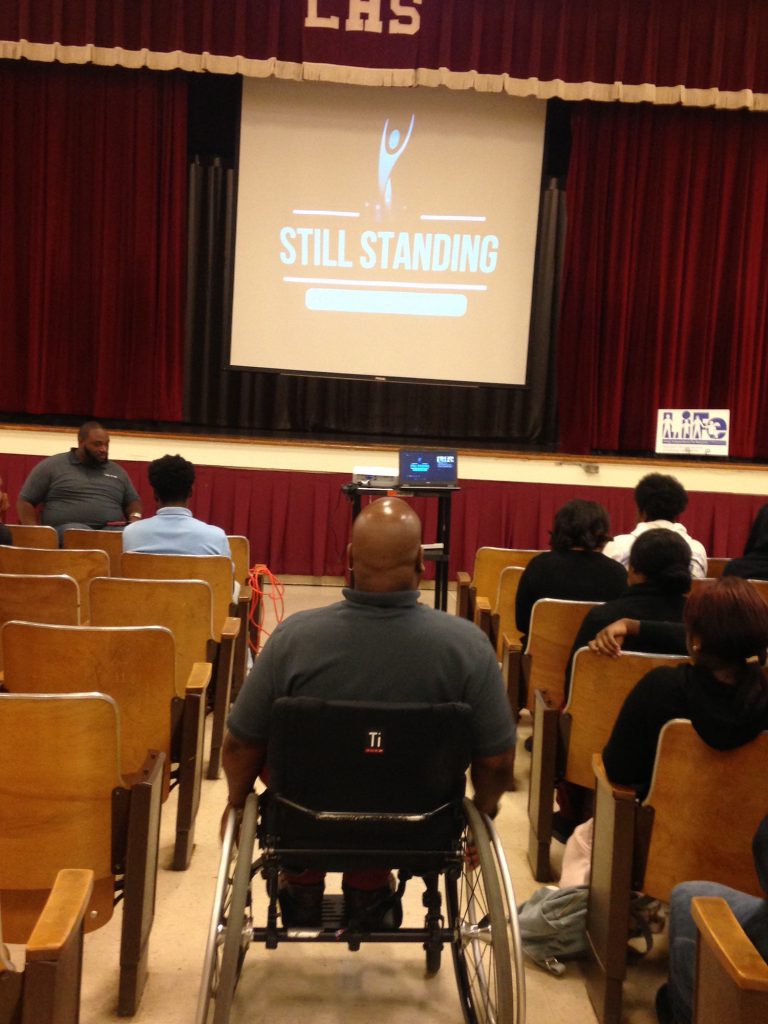 Henderson, foreground, joined the audience that listened as Owens described how he turned tragedy into victory.