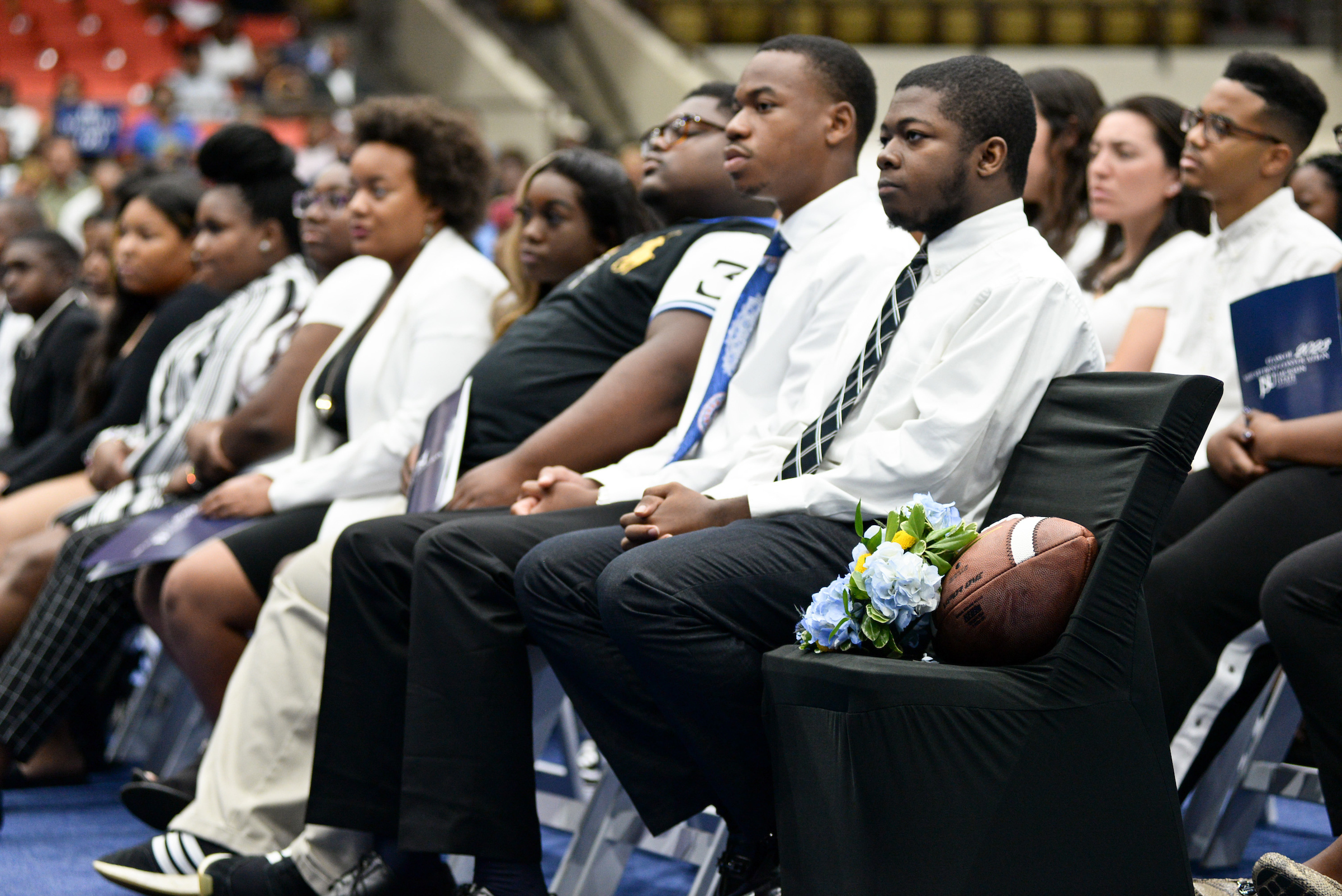 With a football placed on an empty chair, a moment of silence is observed during New Student Convocation as students pay respect to incoming JSU football player Leroy Hawkins, 17, who died tragically in early June in Dallas. He was a Top 300 offensive lineman and, reportedly, was 34th in Texas. (Photo by Darek Ashley/Special to JSU)