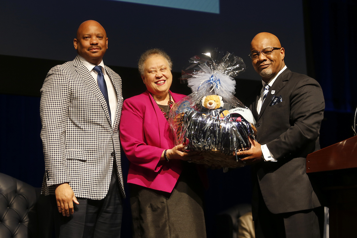Bynum presents Wheelan with a basket that contains JSU memorabilia, souvenirs, keepsakes and other tokens. (Photo by Charles A. Smith/JSU)
