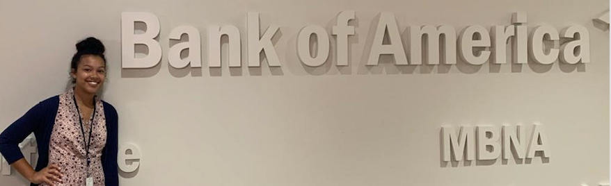 Mariah Adams poses with the Bank of America signage during her 10 week internship as a corporate audit analyst at the Fort Worth, TX branch.