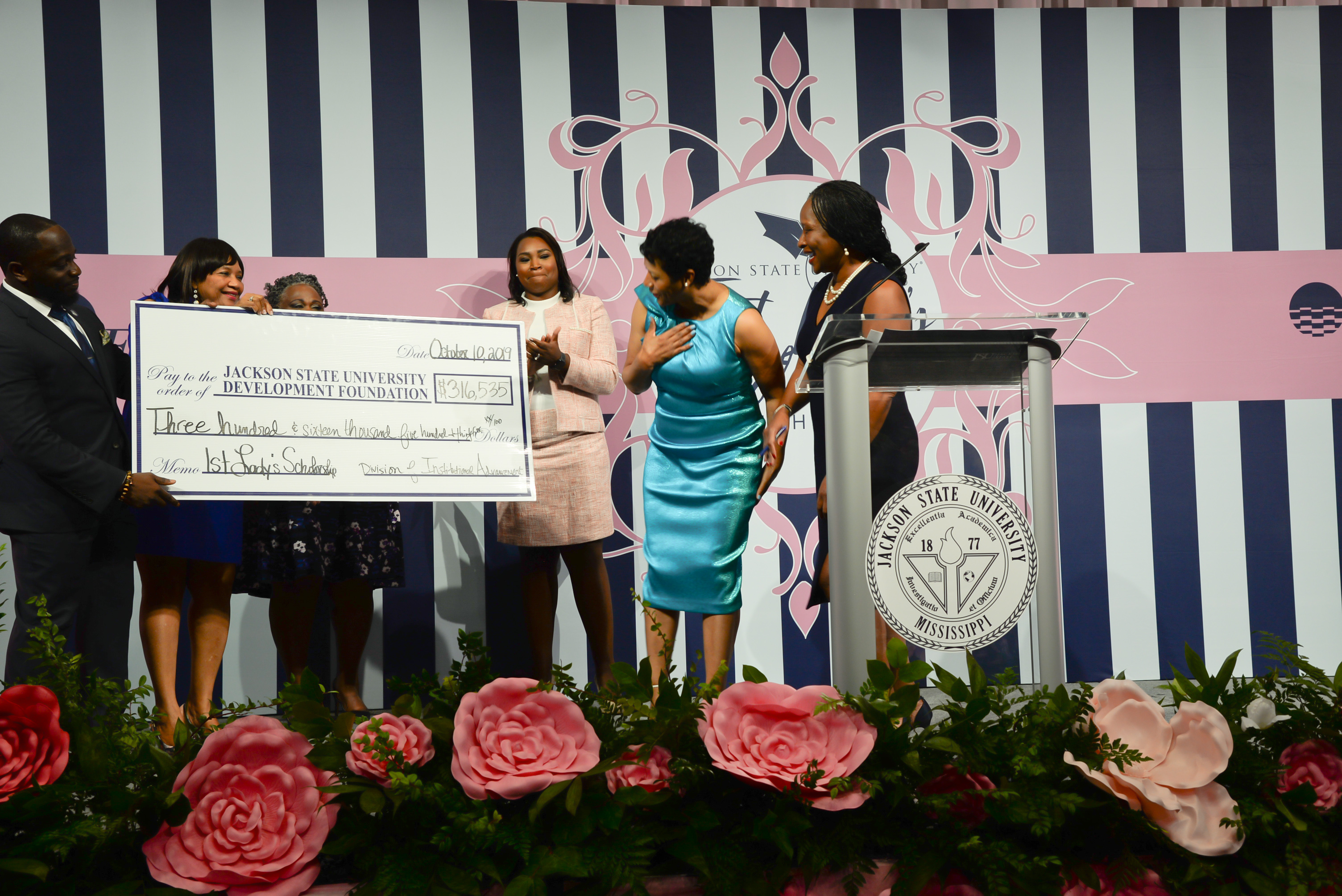 Astounded by the total amount raised for the second annual First Lady's Scholarship Luncheon, Deborah Bynum displays gratitude and joy during the on-stage check presentation.