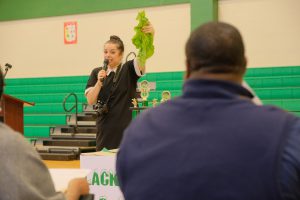 Heather Wilcox, director for JSU's CUBD shows the audience the size of the greens picked from the learning garden and also used for the cook-off.