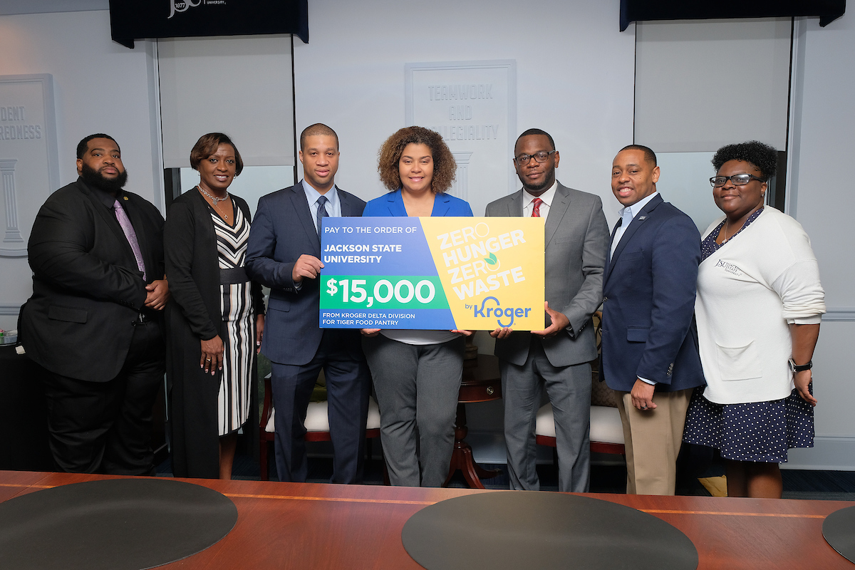 JSU Acting President Thomas Hudson, third from left, receives a gift card from Kroger representatives. Joining him are, Sean Wallace, left, director of Alexander East Residence Hall and JSU Tiger Pantry assistant; Dr. Susan E. Powell, associate vice president for Student Affairs; Jonathan Demming, a JSU alum and I-55 Kroger store leader; Teresa Dickerson, corporate affairs manager for the Kroger Delta Division; Ashley Robinson, JSU’s vice president and director of athletics; and Tammy Timbers, executive director of Housing and Residence Life. (Photo by Charles A. Smith/JSU)