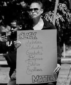 One protestor appears to display what she feels is being choked out by racially-motivated violence toward Black people. (Photo by Wakil Atig)