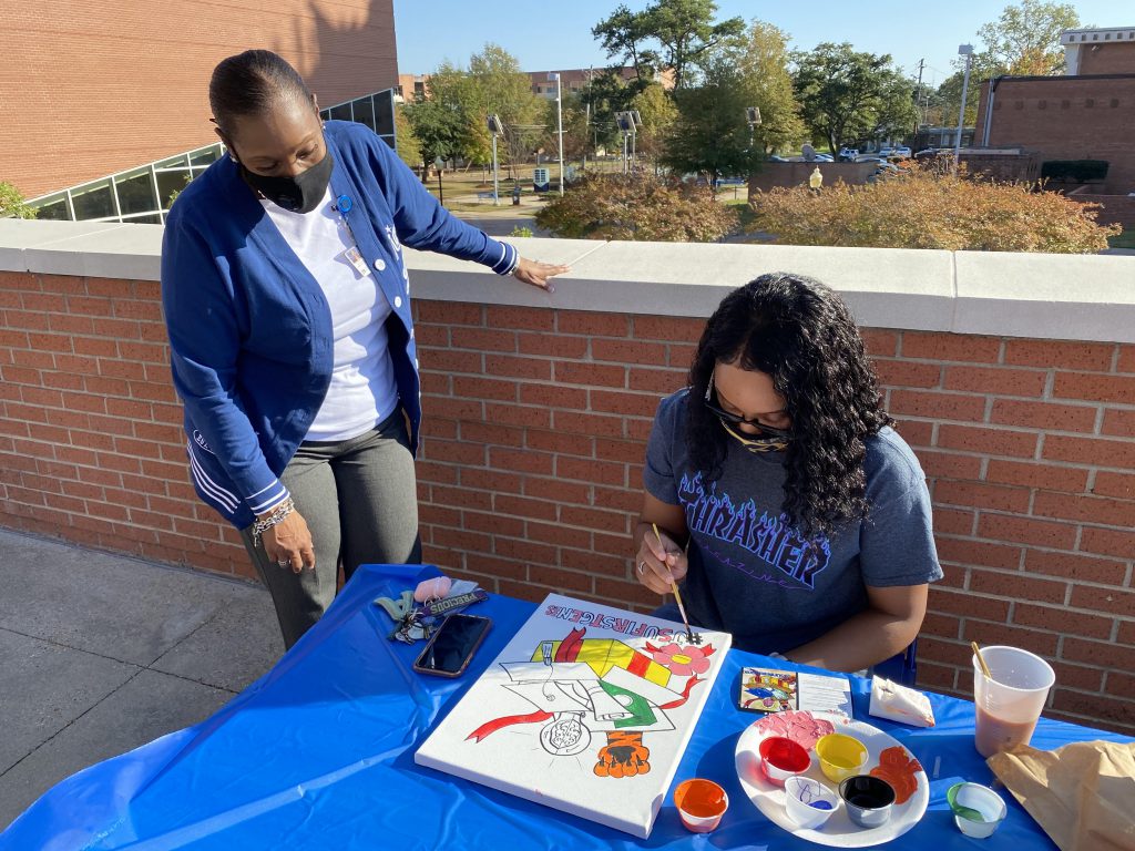 A first-generation student participates in a Patio Paint Kickback at the Student Center.