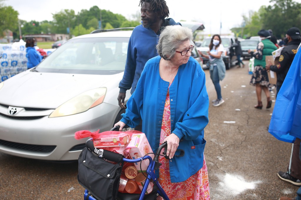 Marge Lairg walked to the event with help from John Slater. She said the food will help feed her great-grandson. (Photo by William H. Kelly III/JSU)
