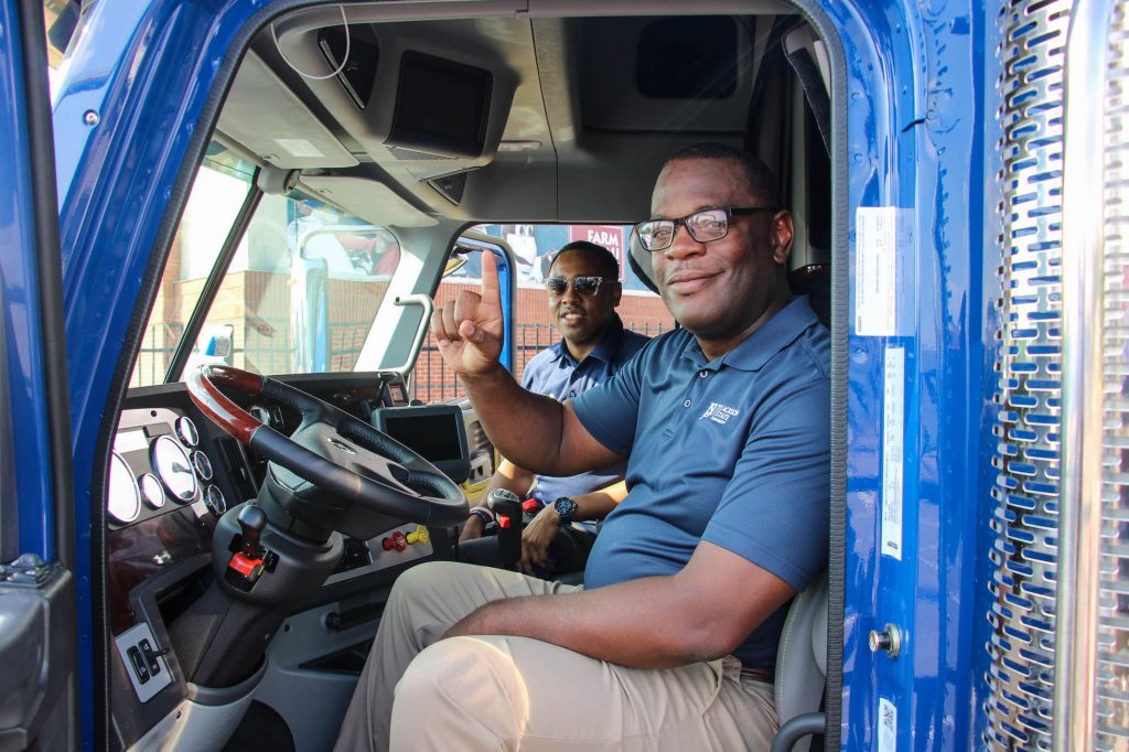 Behind the steering wheel, Hudson inspects the interior with Robinson. The truck will be on display during home games.