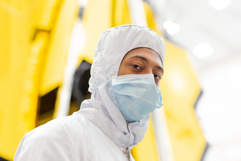 Balancing on a lift, Douglas Williams II moves into position to begin an operation to remove Photogrammetry targets from the telescope before it could begin space environmental testing. (Photo courtesy of Northop Grumman)