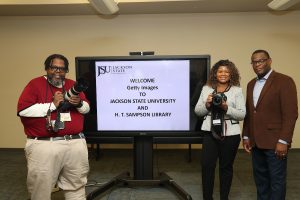University Photographer Charles A. Smith, Chief Communications Officer Alonda Thomas and President Thomas K. Hudson, J.D., show off the new equipment donated by Getty Images and Canon.