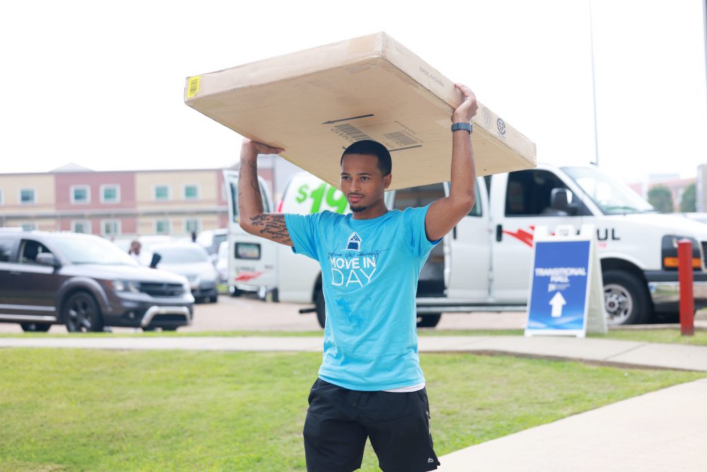A volunteer flexes his move-in day skills. Many student organizations and volunteers were on hand to assist family's with their new or returning student. (Photo by William Kelly, III/JSU)