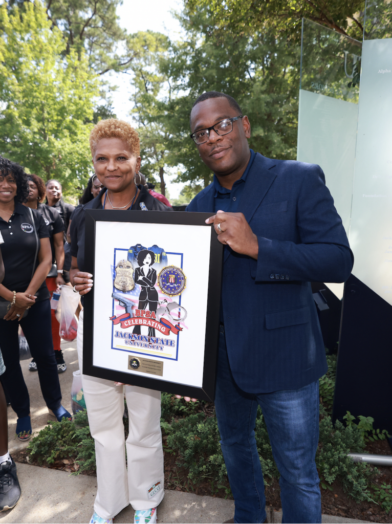 JSU alumna Jennifer Love retired from the FBI after 27 years. She presents JSU President Thomas K. Hudson, J.D. with a gift on behalf of the women FBI agents during a check presentation on Friday, Sept. 16. (Photo by Charles A. Smith/JSU)