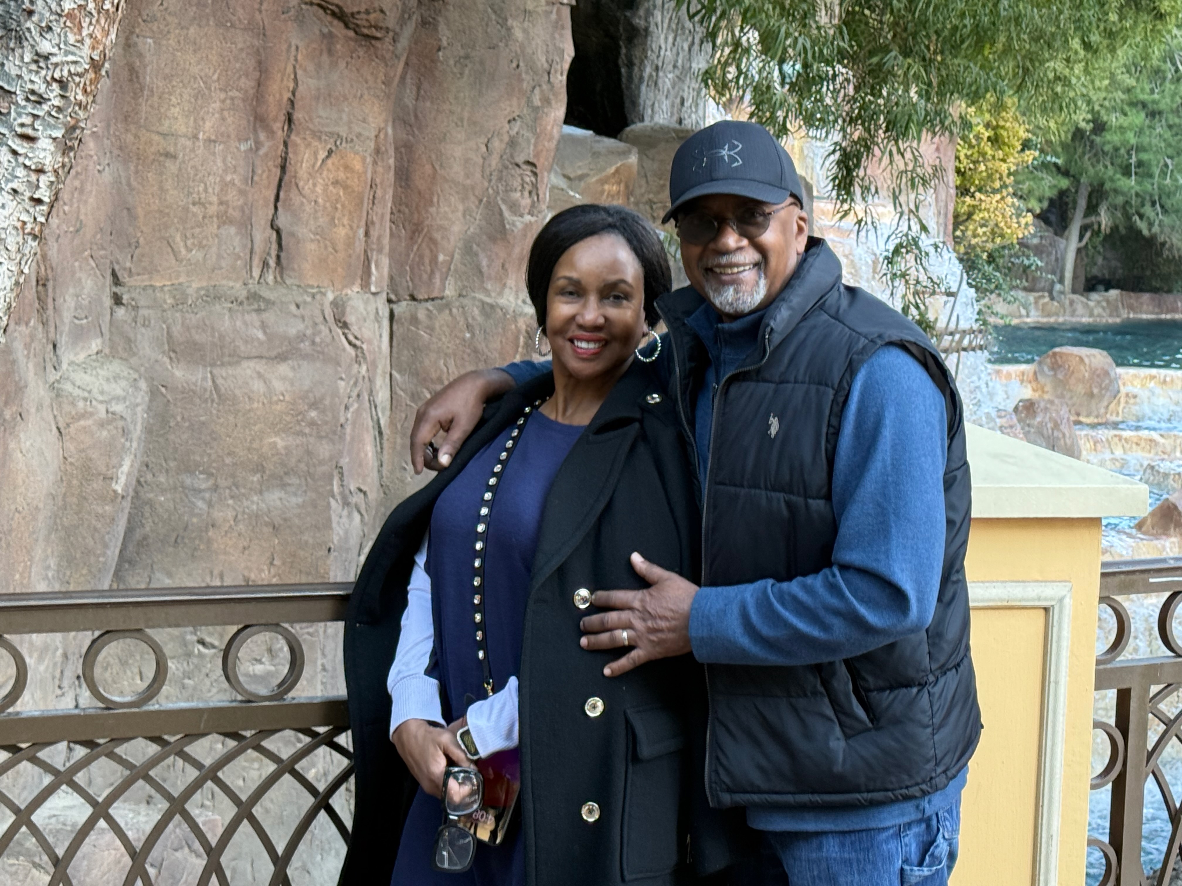 Dowell and Vivian Taylor pose in front of a rock wall and water