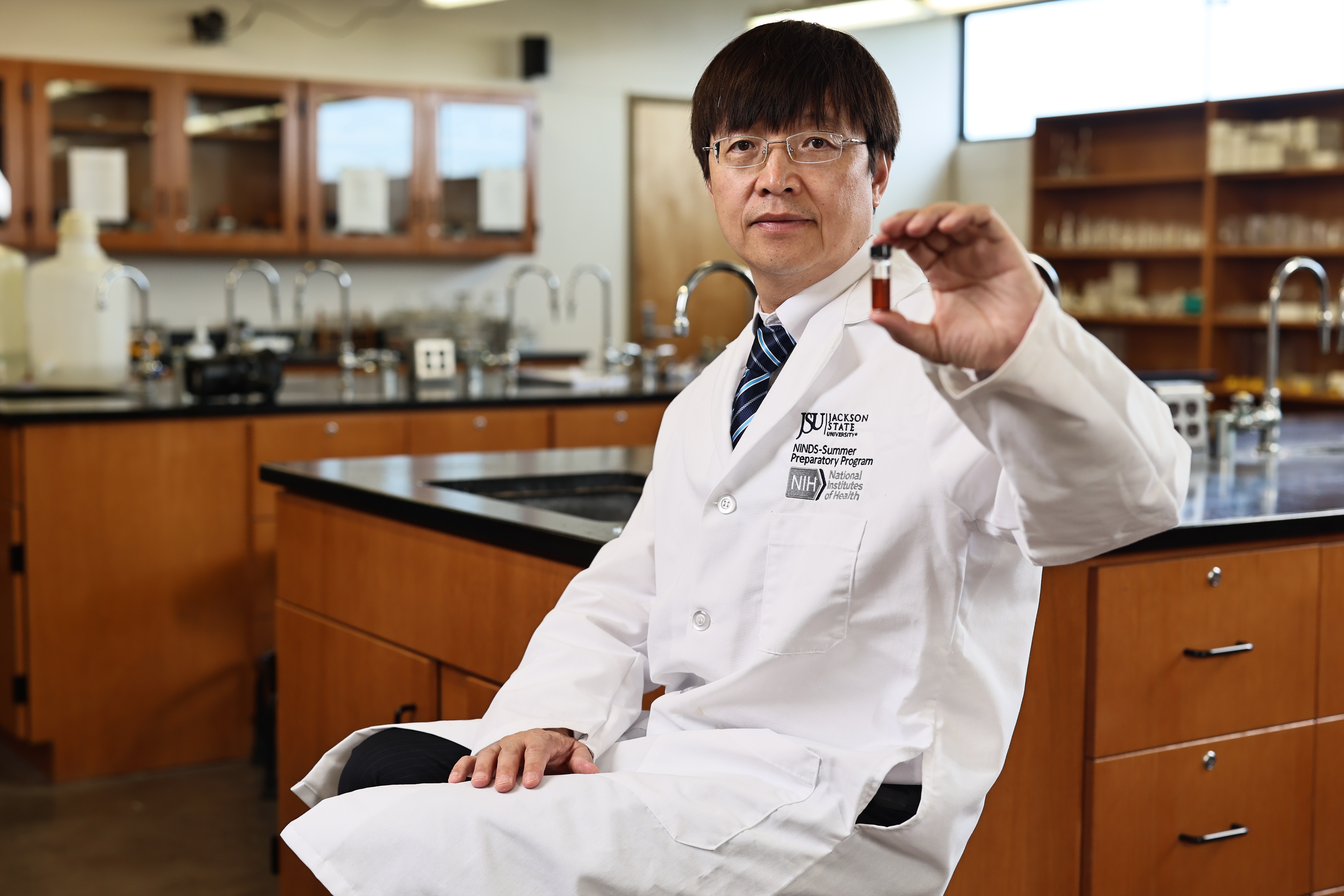 Yongfeng Zhao, Ph.D., JSU associate chemistry professor, holds a solution containing water-soluble magnetic nanomaterials.